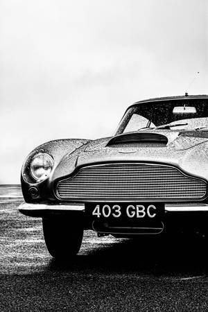 經典 Aston Martin，引擎蓋和格柵上有雨滴。
