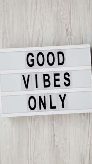 一個燈箱，在木質背景上顯示訊息「GOOD VIBES ONLY」。
