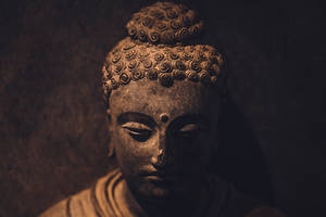 在溫暖昏暗的燈光下閉著眼睛的寧靜佛像
