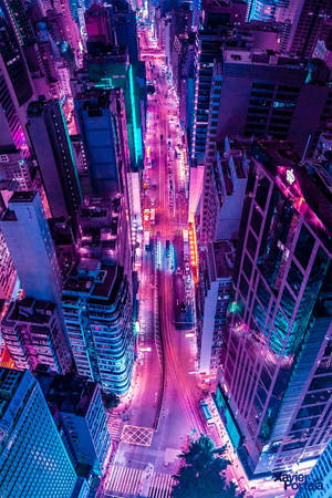 夜晚鳥瞰一條充滿活力的霓虹燈街道，周圍是高樓大廈。 — 夜景城市 壁紙