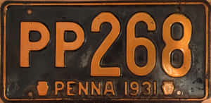 磨損的1931年賓夕法尼亞州車牌，黑色背景上帶橙色字母。 — 汽車 壁紙
