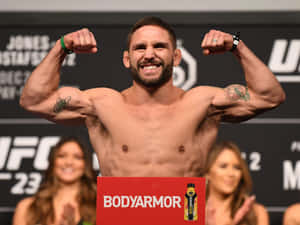 UFC拳手在稱重活動中彎曲手臂，帶有BodyArmor標誌。
