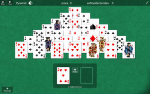 綠色氈布上的金字塔接龍紙牌遊戲，卡片排列成金字塔形狀。