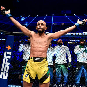 UFC拳手在八角籠內高舉雙臂慶祝勝利。