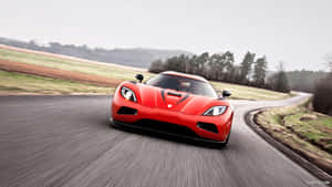 紅色 Koenigsegg 在蜿蜒的鄉村道路上疾馳。