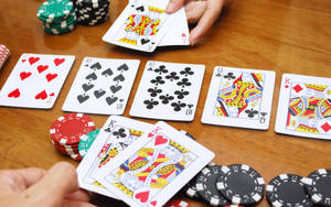 撲克牌遊戲進行中，木桌上有紙牌和籌碼。