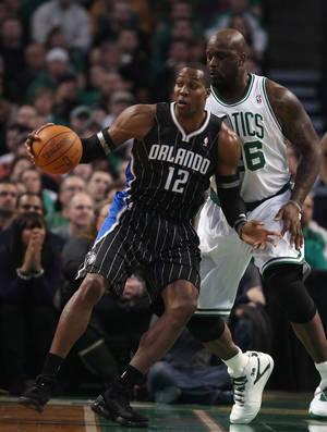 奧蘭多魔術隊球員在NBA比賽中運球越過波士頓塞爾特人隊防守者。