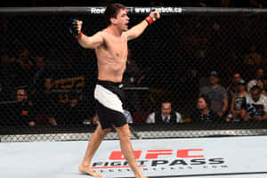 MMA選手在UFC八角籠內高舉雙臂慶祝勝利。 — 冠軍 壁紙