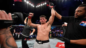UFC拳手在八角籠內與裁判一同舉手慶祝勝利。