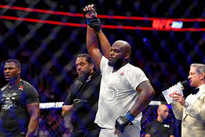 UFC拳手在八角籠中舉拳慶祝勝利。 — 勝利 壁紙