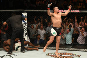 MMA拳手在八角籠中擊敗對手後高舉雙臂慶祝勝利。
