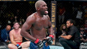 UFC戰士在濕滑的八角籠內伸出舌頭慶祝勝利。
