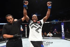 UFC拳手高舉雙臂慶祝勝利，裁判舉起他的手。