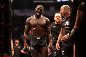 UFC拳手在八角籠中伸出舌頭慶祝勝利。 — 冠軍 壁紙