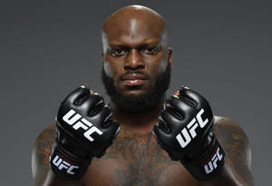 一個光頭、留鬍子的UFC拳手，戴著黑色手套，身上有紋身，正銳利地看著鏡頭。