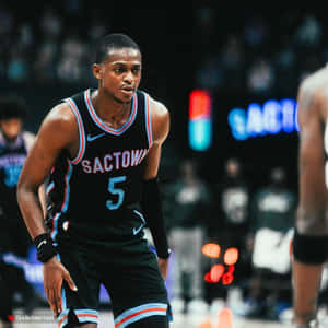 籃球運動員穿著黑色Sactown球衣號碼5在比賽中的球場上
