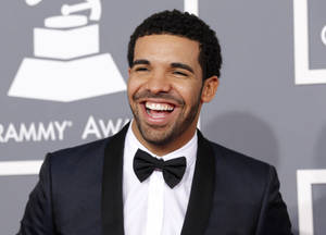 Drake 在格林美獎活動中穿著燕尾服開懷大笑。