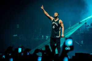 Drake 穿著速龍隊球衣在藍色舞台燈光下現場表演。