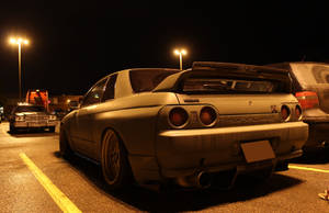 一架啞光灰色日產Skyline R32在夜晚停泊在停車場的街燈下。 — 夜晚 GIF 壁紙