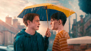 兩個年輕男子在雨中於城市街道上共用一把雨傘。