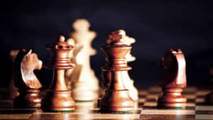 木製國際象棋棋子喺棋盤上，帶有戲劇性燈光。 — 國際象棋 壁紙