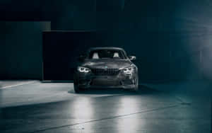黑色BMW M2跑車在昏暗車庫中被聚光燈照亮，伴有薄霧。