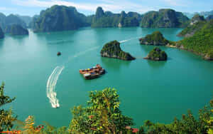 快艇在翠綠的喀斯特島嶼之間的碧綠海水中留下白色航跡。
