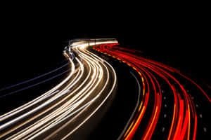 夜間黑暗高速公路上行駛車輛的紅色和白色光條。