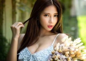 身穿藍色蕾絲上衣的女性在花園中手持乾花