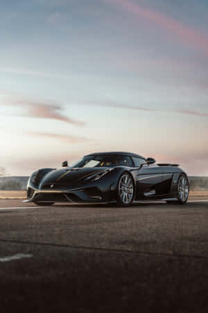 黑色Koenigsegg跑車在瀝青路上，日落時分