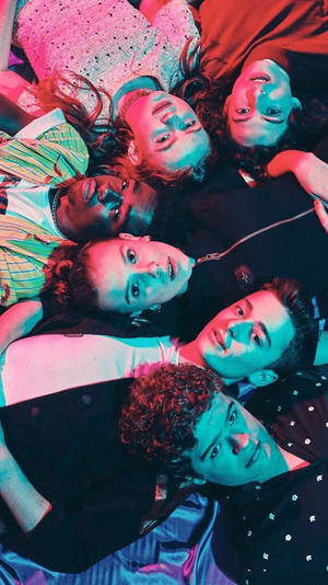 年輕朋友在霓虹燈下圍成圓圈躺著向上看。
