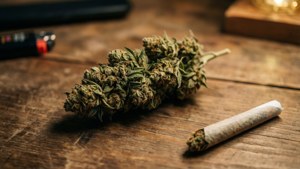 木質表面上的大麻花蕾和捲好的大麻煙，附有打火機。