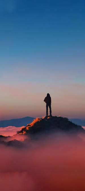 日出時，一個人站在雲海之上的山頂剪影。 — 傷心 壁紙