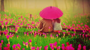 兩個人在粉紅花田裡一起坐在粉紅色的雨傘下。