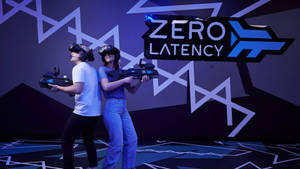 兩名戴著VR頭戴式裝置的玩家在主題競技場中手持虛擬現實槍械。 — 槍 壁紙