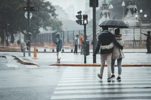 情侶在雨中街道上共用一把傘行走。