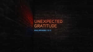 霓虹燈招牌在黑暗的磚牆上顯示 Unexpected Gratitude 和 Philippians 1:3-11。