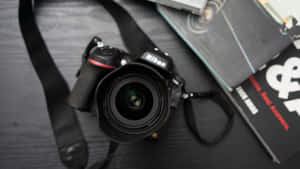 Nikon DSLR相機和攝影書籍在深色木質表面上