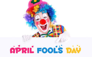 一個微笑的小丑，彩虹頭髮，拿著一個寫著April Fools Day的標牌。