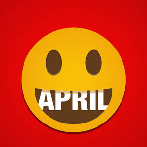 黃色笑臉露出牙齒，在紅色背景上顯示「april」這個詞。