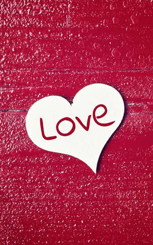 白色心心剪紙，紅色 'Love' 文字，放在帶水滴的紅色紋理背景上。