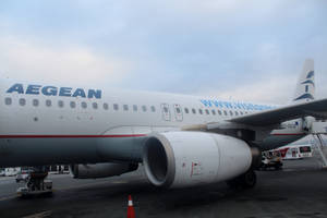 愛琴海航空飛機停泊在機場閘口，附有地勤設備