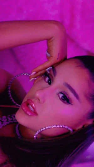 Ariana Grande 在粉紅色燈光肖像中佩戴鑽石耳環。