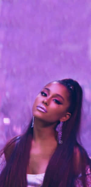 Ariana Grande 在紫色燈光下的肖像，化著閃亮妝容，戴著垂墜耳環。