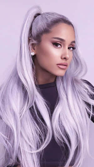 Ariana Grande 留著銀色頭髮，梳成高馬尾，身穿黑色上衣。