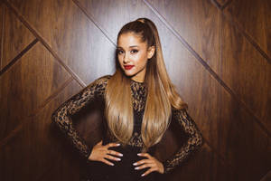 Ariana Grande 身穿黑色蕾絲連衣裙在木牆前擺姿勢
