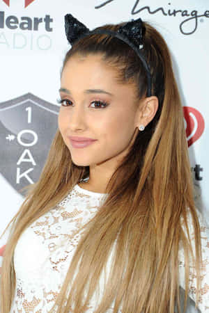 Ariana Grande 在活動中戴著貓耳頭帶和白色蕾絲上衣。