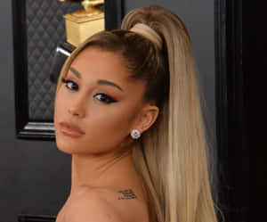 Ariana Grande 在格林美活動中留著高馬尾和戴鑽石耳環。