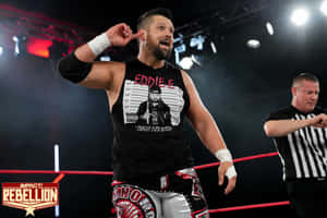 摔角手 Eddie Edwards 在 Impact Rebellion 活動期間與裁判在擂台上。