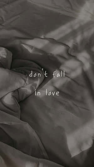 皺褶灰色布料上的文字疊加顯示 don't fall in love。